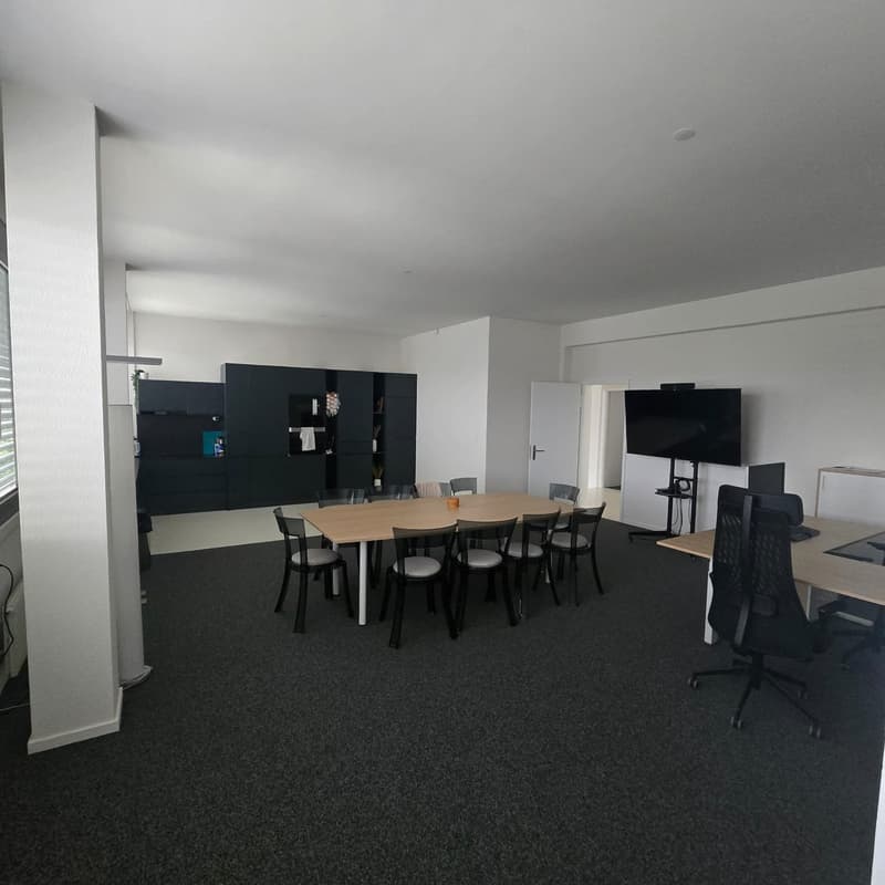 modern office room with large desk, cabinets, TV, monitors, office chairs