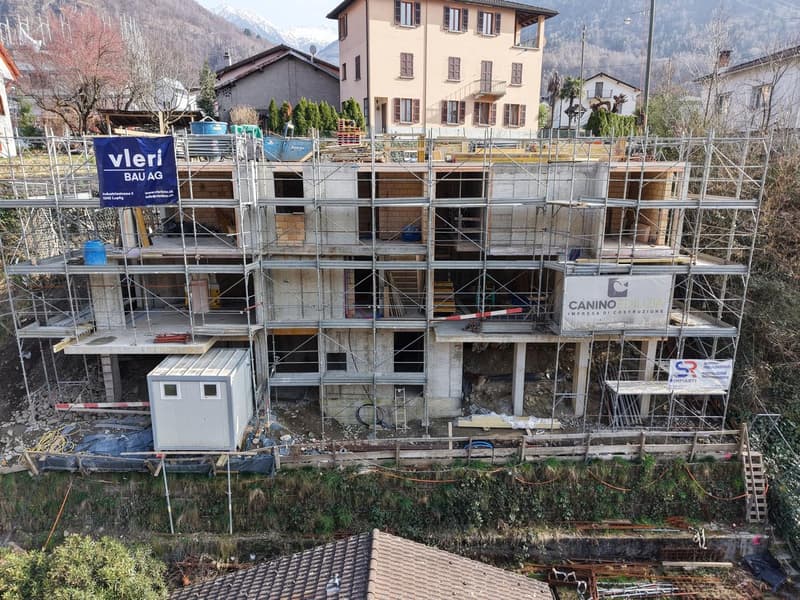Under construction building, scaffolding, multiple floors, signboards, construction materials