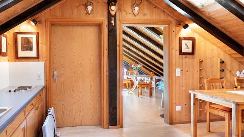 wooden door, wooden cabinets, wooden floor, dining table, dining chairs, gas stove, sink, mounted pictures