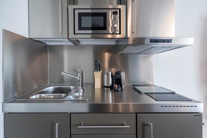 Stainless steel kitchen with built-in microwave, sink, and countertop space