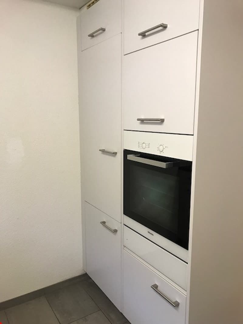 modern white cabinets, black and silver oven, stainless steel handles, tiled floor