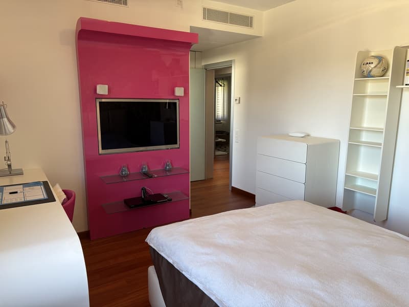 bed, desk, pink wall, television, shelves, white cabinet