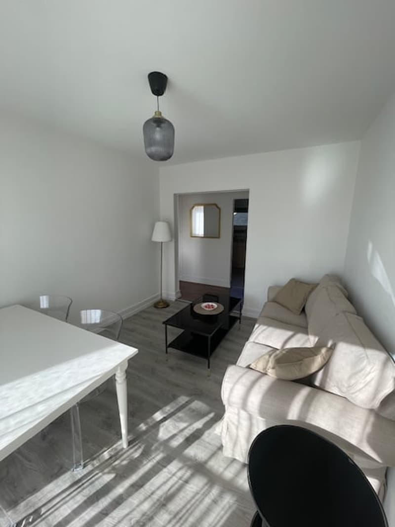 Minimalist living room, white walls, beige couch, white table, coffee table, floor lamp