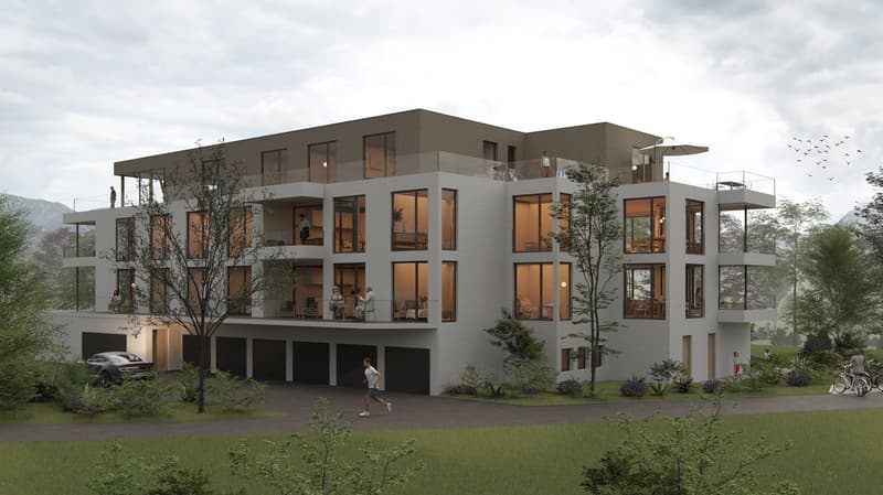 Modern apartment building, 4 stories, white exterior, balconies on upper floors, garages, car parked, driveway, trees, grassy lawn, pathway, mountain view in the background.