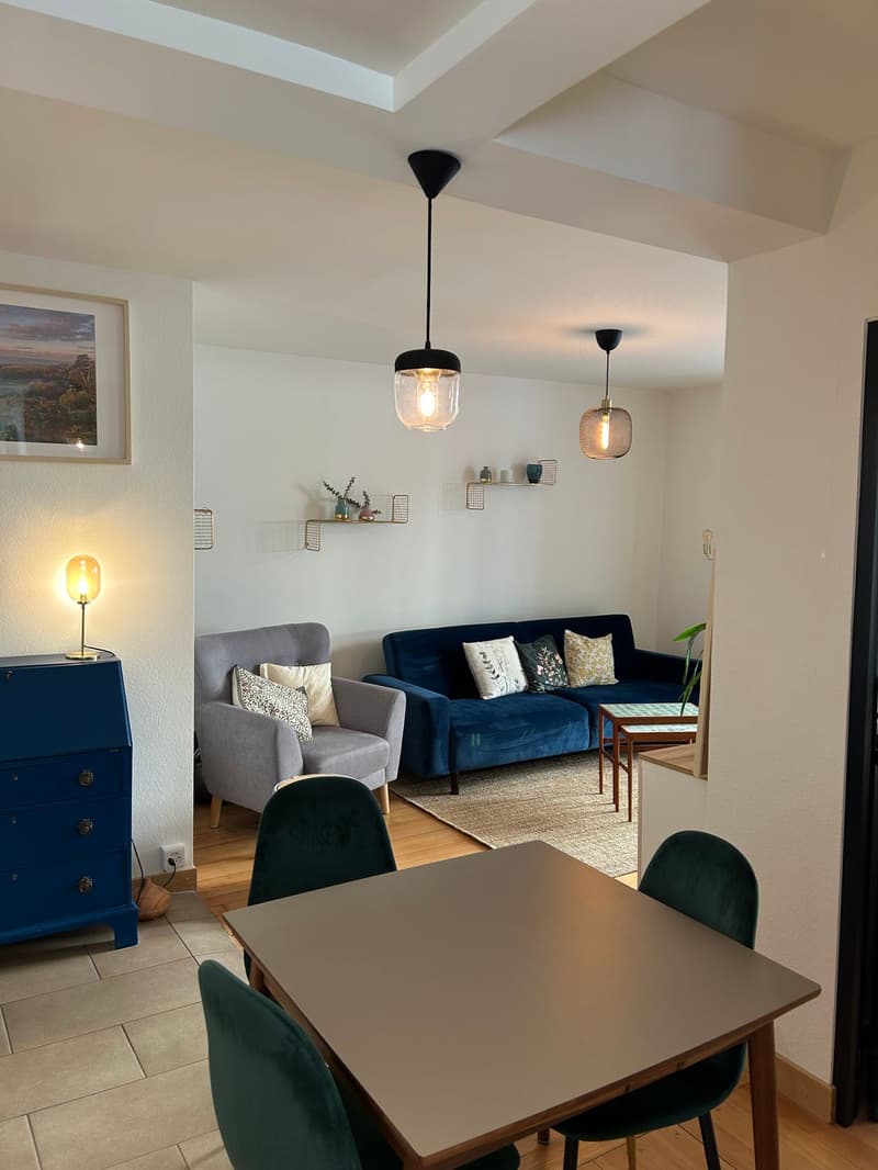 Vue sur la salle à manger, avec le salon en arrière-plan.