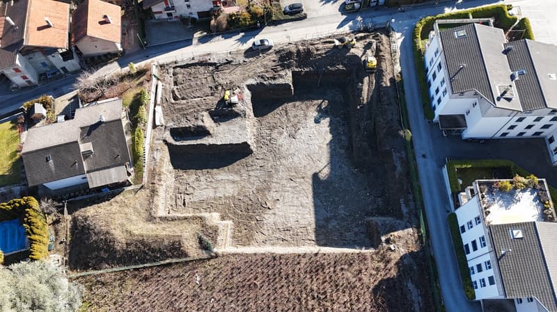 Empty plot with excavation for house foundation.