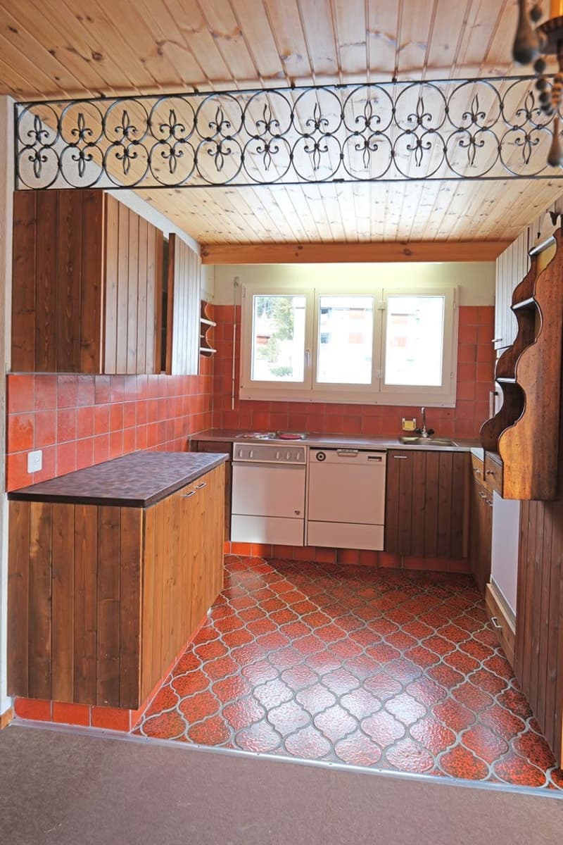 Wooden cabinets, tiled counter, tiled floor, tiled backsplash, dishwasher, fridge, stove, windows