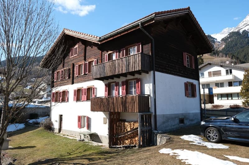 2 story wooden house, red shutters, balcony, snow on ground