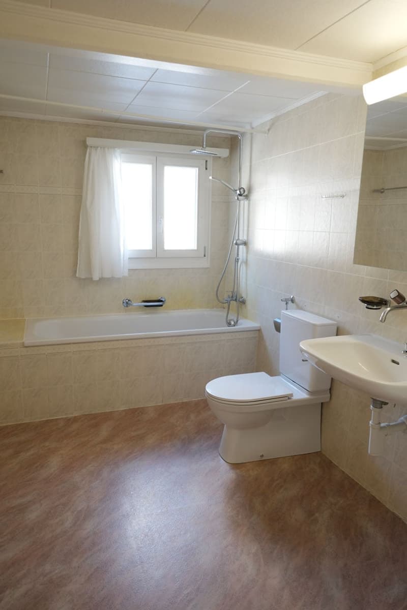 Bathroom with bathtub, toilet, sink, shower, window, tiled walls and floor