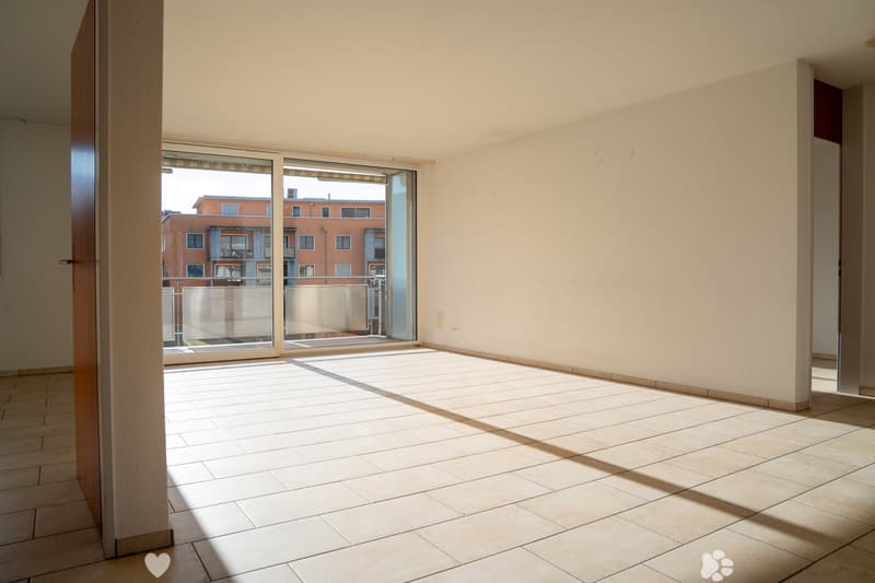 empty room with tile flooring, sliding glass door to balcony, white walls