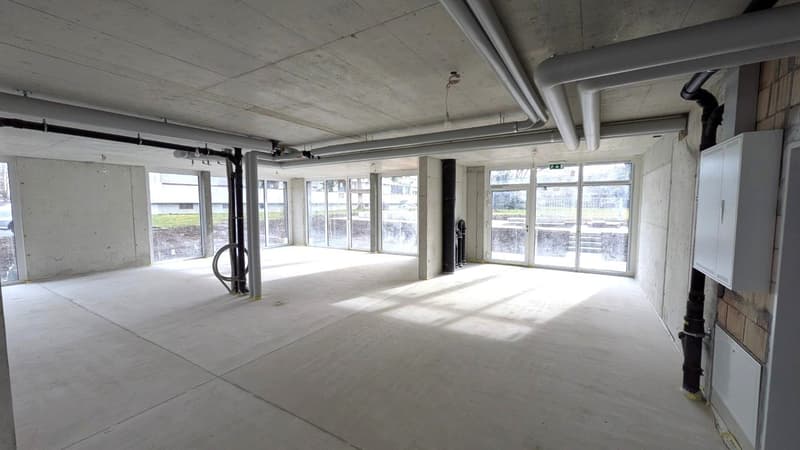 large windows, concrete floor, metal pipes, light fixtures, cabinets
