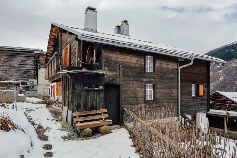 Two story wooden house, two chimneys, windows, wooden door, wooden bench, snow around
