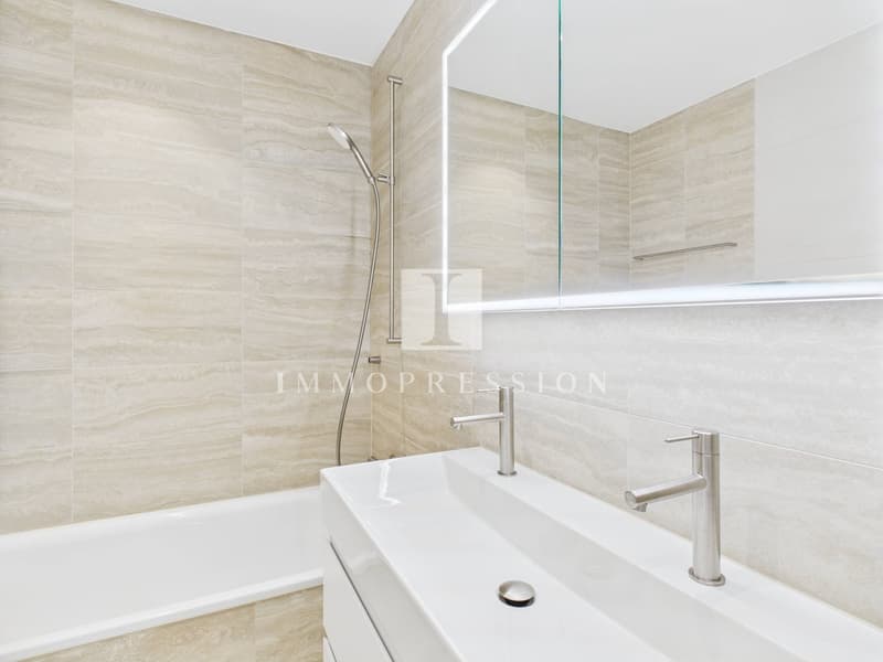 modern bathroom with bathtub, shower, sink, and mirror
