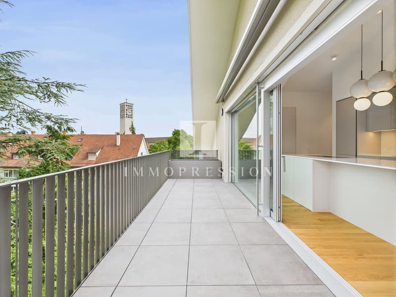 Balcony with tiled floor, metal railing, glass doors, wooden floor inside, modern kitchen
