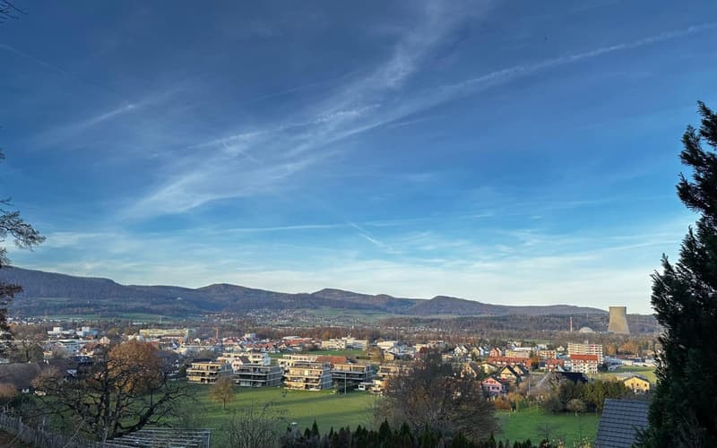 Township with multiple residential buildings, mountains, clear blue sky