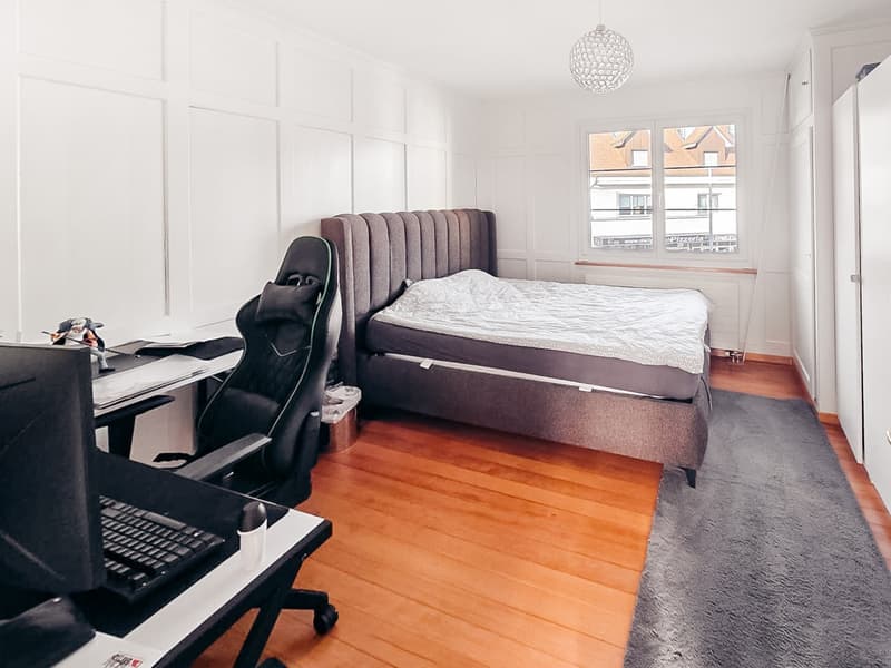 Bedroom with bed, desk, chair, and window