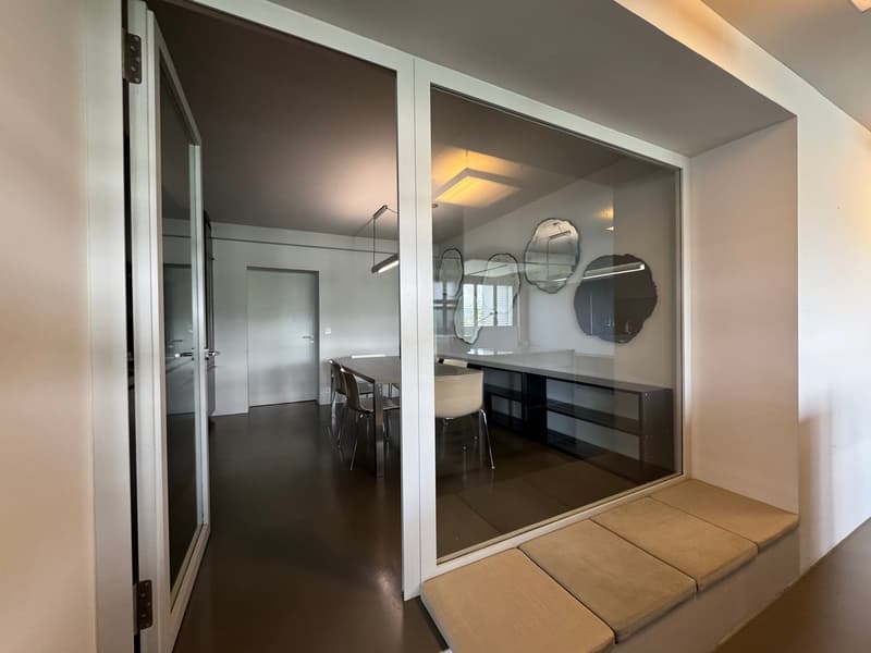 modern dining area with glass walls, wooden floor, table and chairs, built-in bench, mirrors on the wall