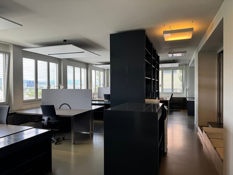 modern office space with desks, chairs, cabinets, and windows