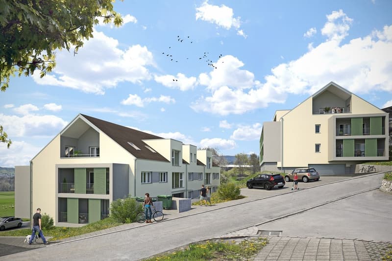 The image shows a residential development with several multi-story apartment buildings. The buildings have a modern, minimalist design with a mix of light and dark colors. There are parking spaces visible in front of the buildings, and people can be seen