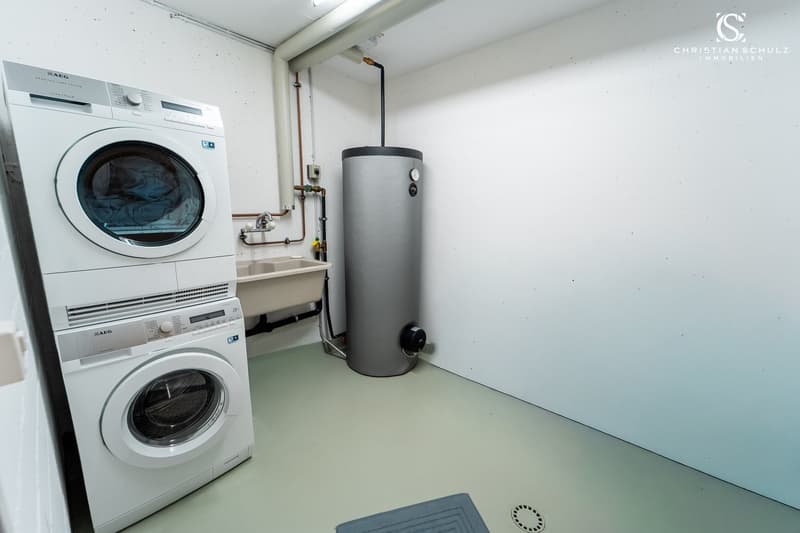 Laundry room with washing machine, dryer, sink, and water heater.