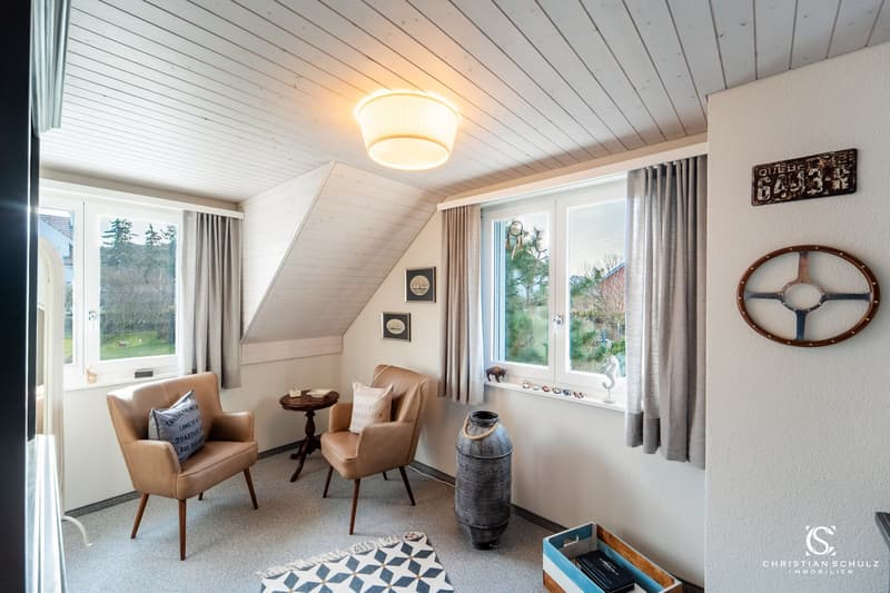 small room with two chairs, table, rug, and decorative items