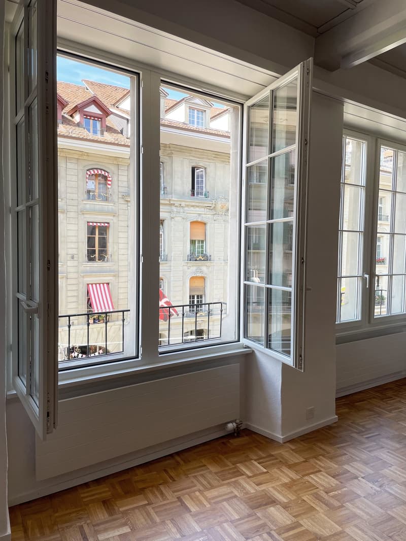 Empty room with large windows and balcony access, parquet floor