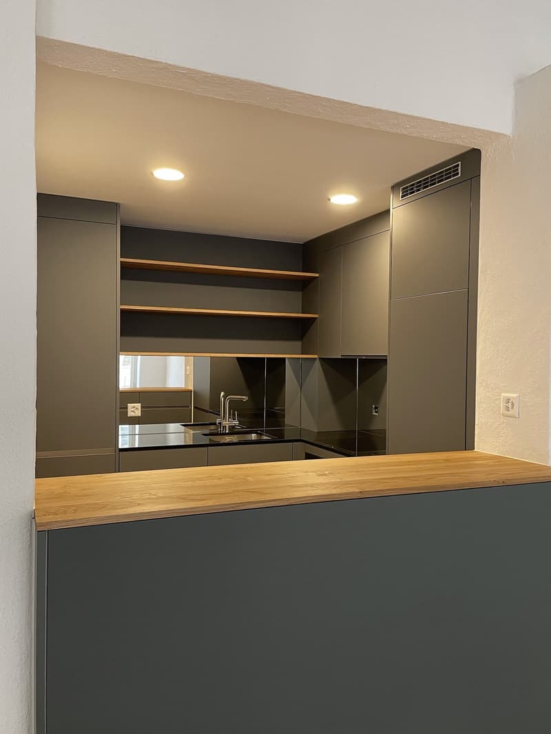 modern kitchen, stainless steel sink, wooden countertops, black and gray cabinets, stainless steel faucet, mirror on wall