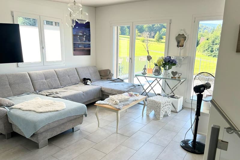 large sofa, coffee table, side table, glass doors, balcony, view of the outside