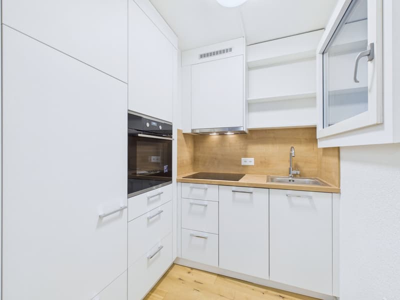 white cabinets, wooden countertops, stainless steel sink, built-in oven, dishwasher, power outlet