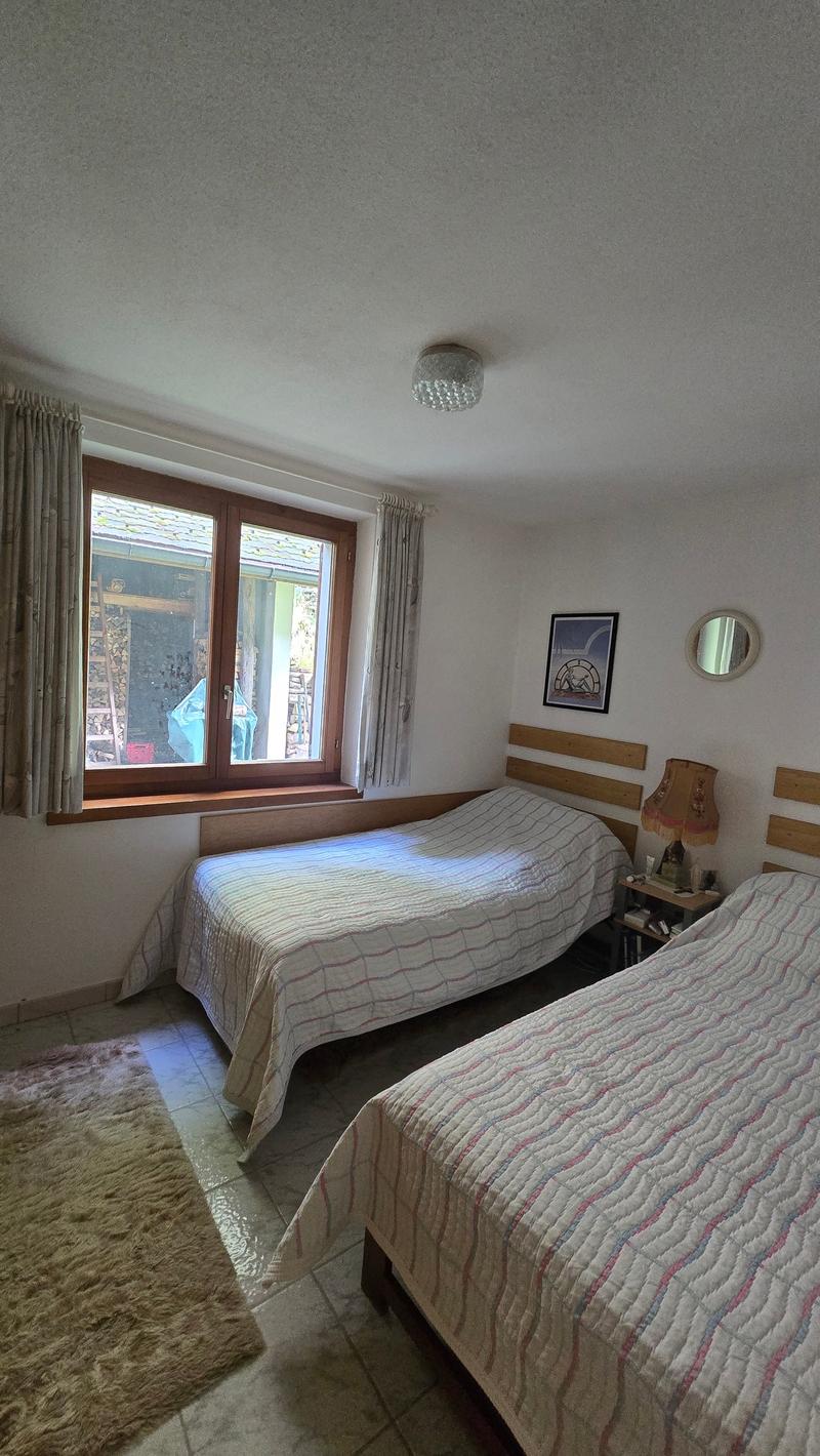 bedroom with two beds, wooden headboard, carpet, window, framed picture, mirror, nightstand, lamp