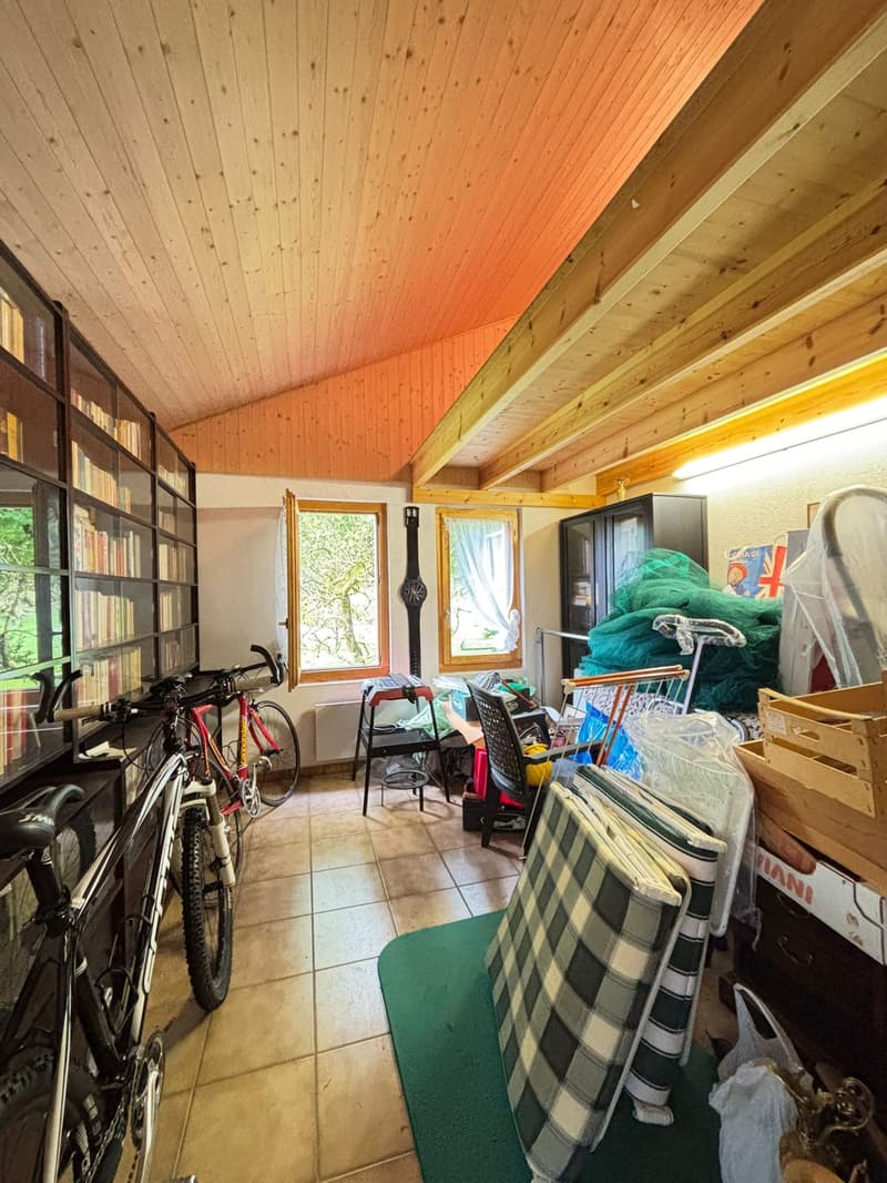 Storage room, wooden ceiling, bicycles, bookcases, windows, chairs, clutter