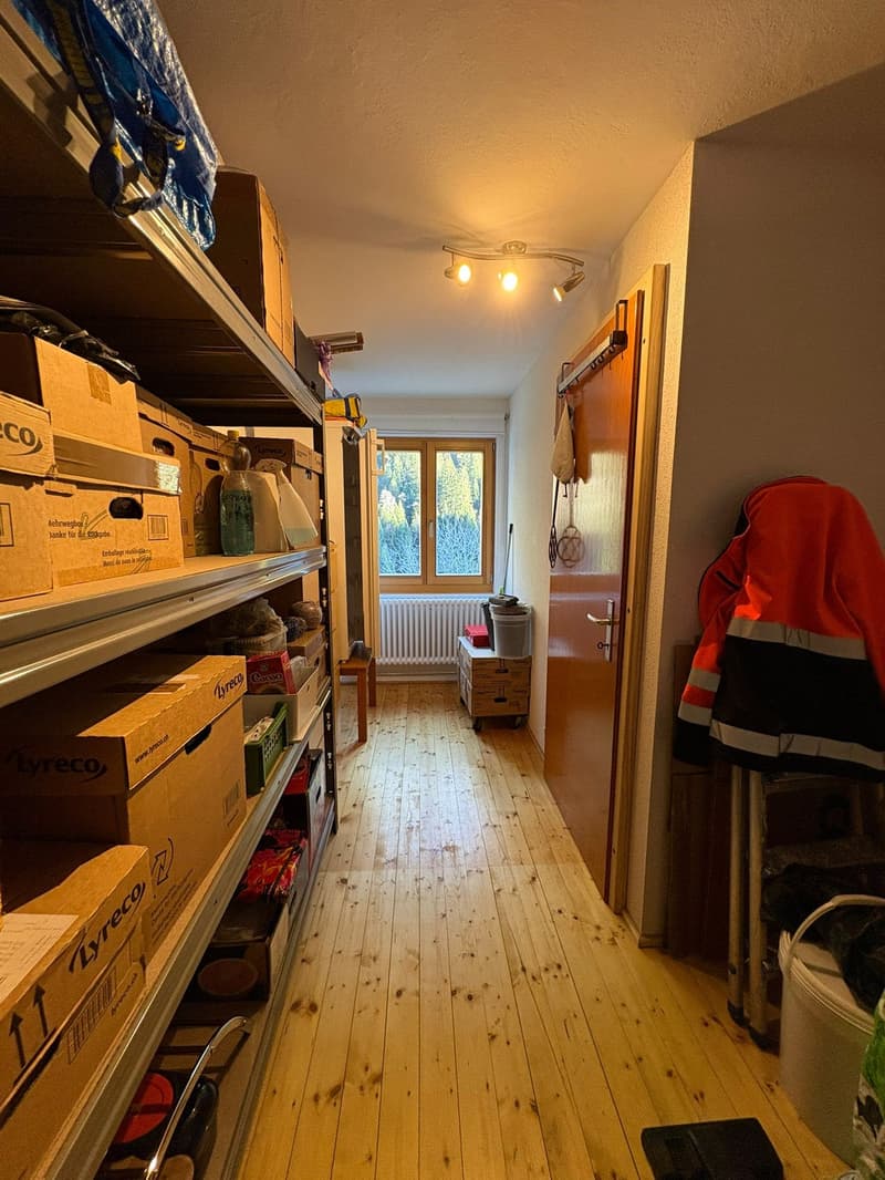 long corridor, storage shelves, cardboard boxes, illuminated ceiling, wooden floor, window