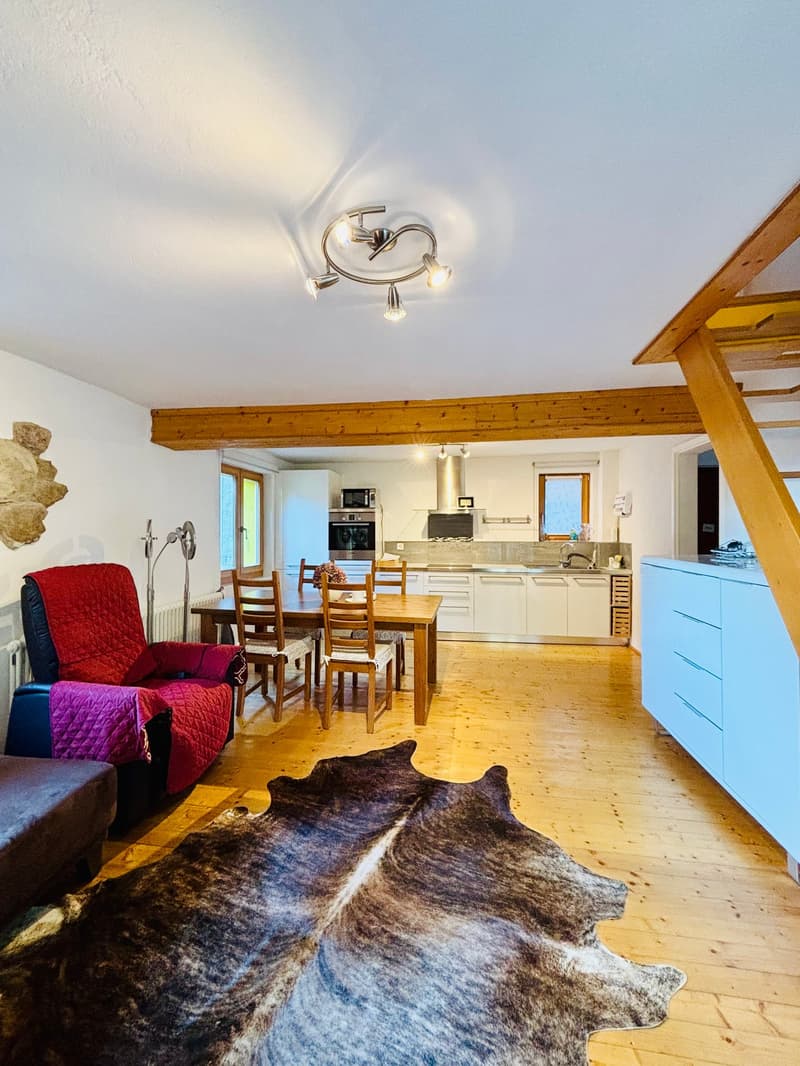 living room, wooden floor, kitchen with dining table, microwave, fridge, dining area, 2 chairs, 2 lamps, wooden beams, radiator