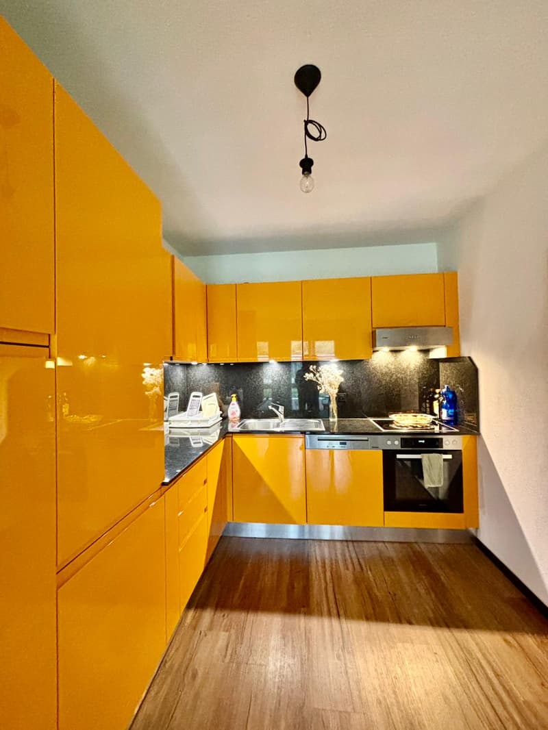 modern kitchen with yellow cabinets, wooden floor, stainless steel oven, dishwasher, sink