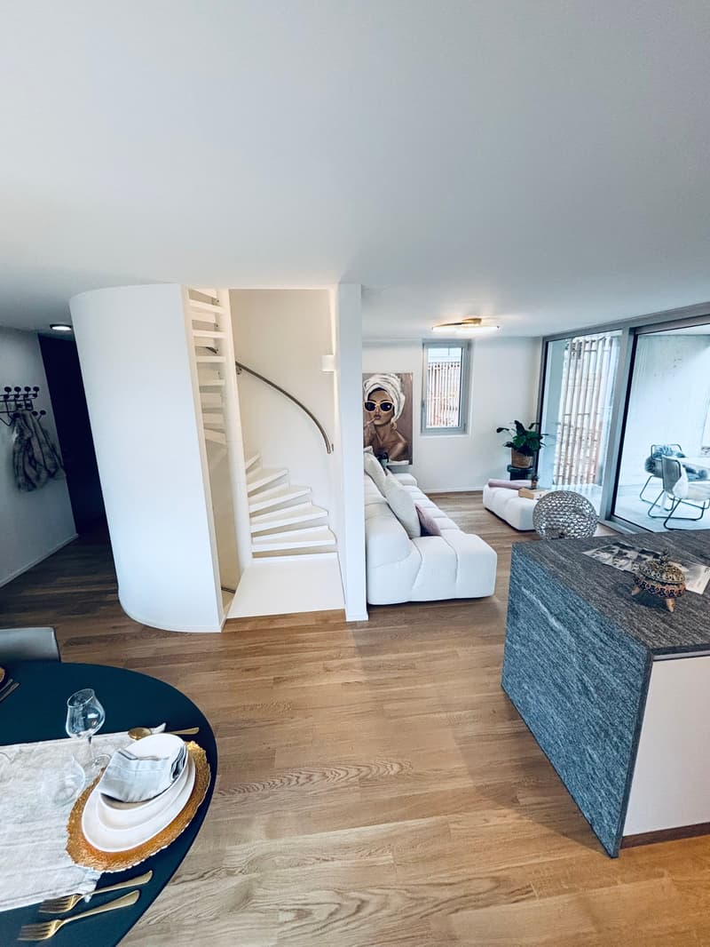 wooden floor, white walls, spiral staircase, white sofa, dining table, chandelier light