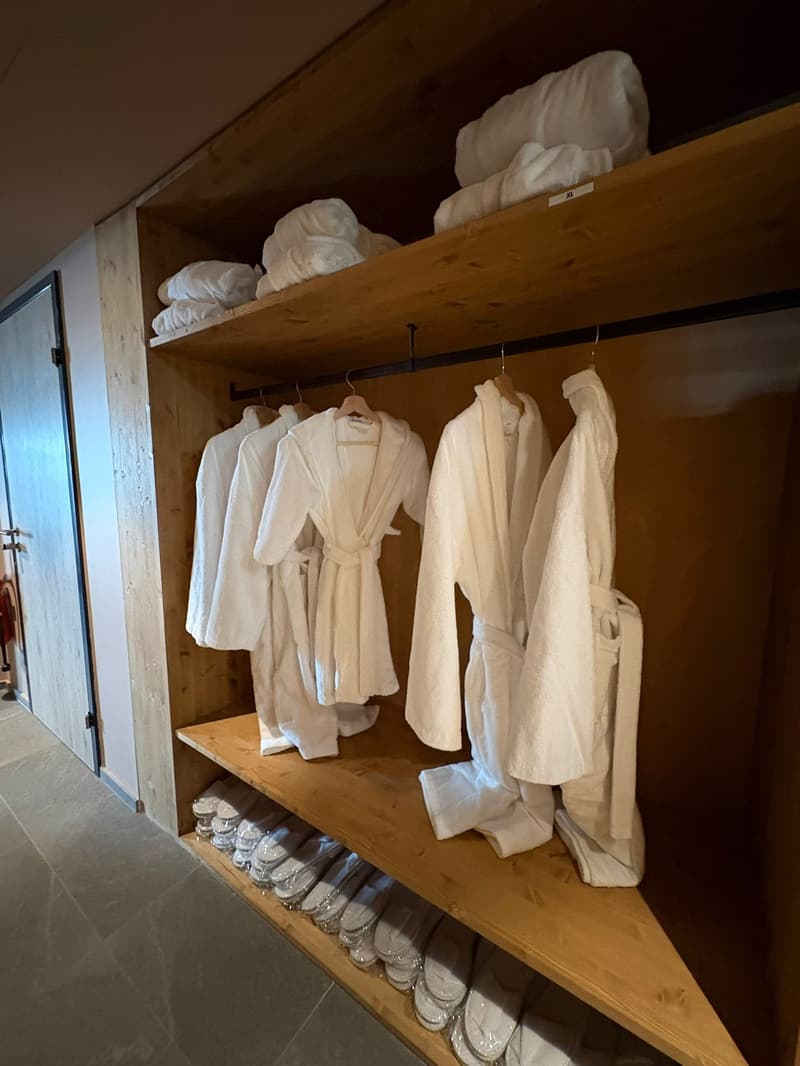 wooden shelf with white towels and robes