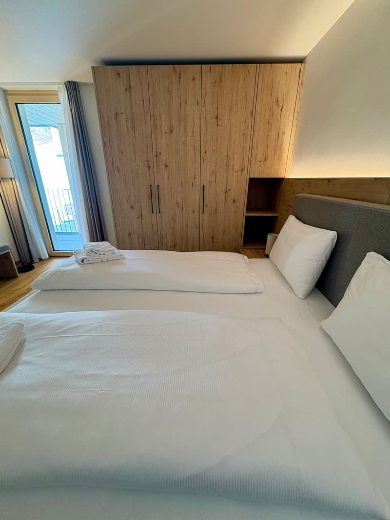 2 single beds, wooden wardrobe, view of the outside