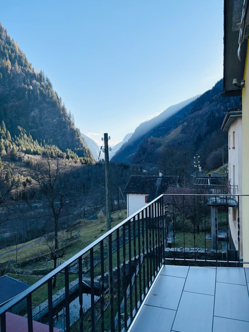 Balcony with metal railings, tiled floor, view of mountains and valley