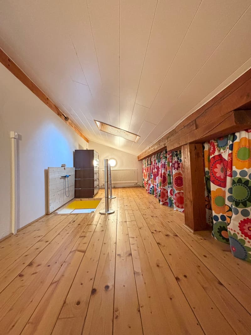 wooden floor, white walls, wooden beams, radiator, wooden storage unit, yellow floor trapdoor, decorative curtains