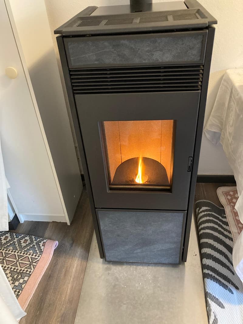 Fireplace in the corner of the room, with a lit fire inside
