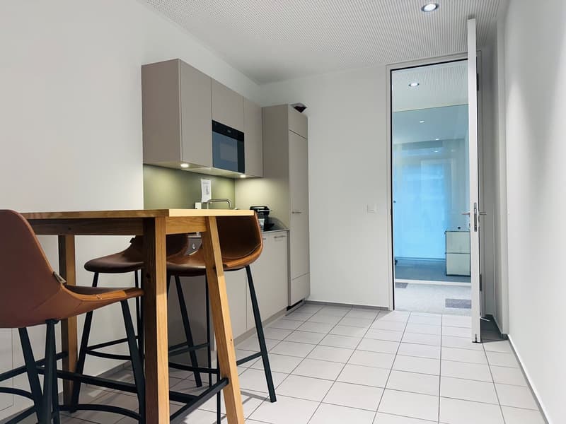 modern kitchen with wooden table, brown leather chairs, white tiled floor, built-in microwave, sink, cabinets, open door