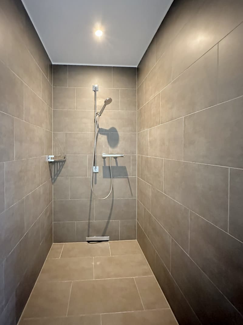 shower with ceiling light and tiled wall and floor