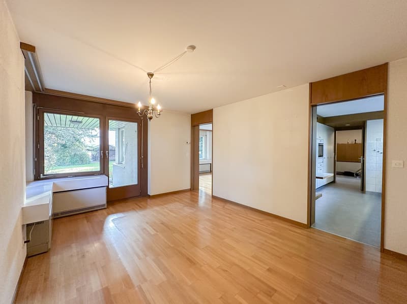 room with wooden floor, glass doors, open space, chandelier, white walls