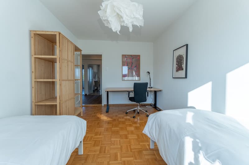 Two single beds, bamboo shelving, desk with chair, framed pictures, lamps