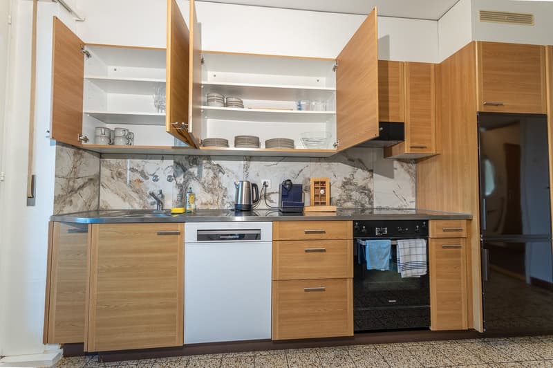 modern kitchen with wooden cabinets, granite countertop, stainless steel sink, dishwasher, gas stove, microwave, refrigerator, and a wine cooler