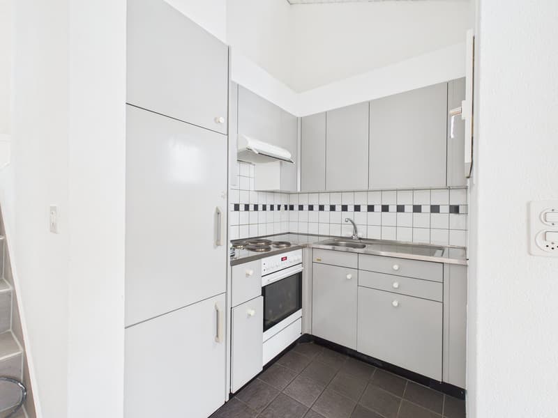 Modern minimalist kitchen, white cabinets, tiled backsplash, stainless steel sink, built-in electric stove, oven