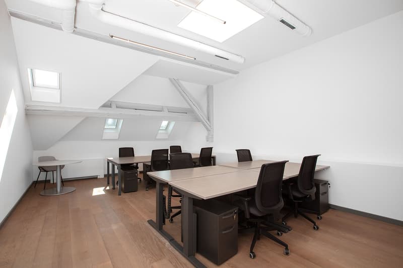 office room with wooden floors, white walls, large windows, office tables and chairs, a round small table