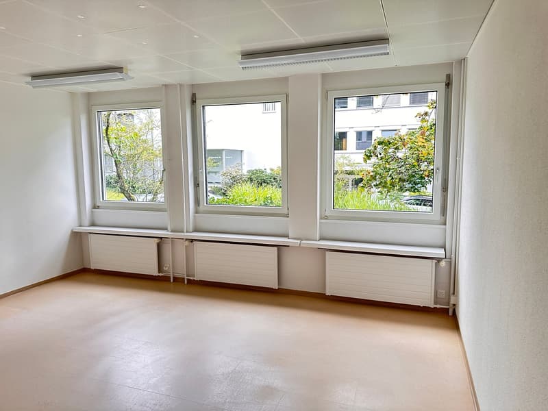 tiled floor, white walls, three large windows, white window benches, white ceiling panels, ceiling lights
