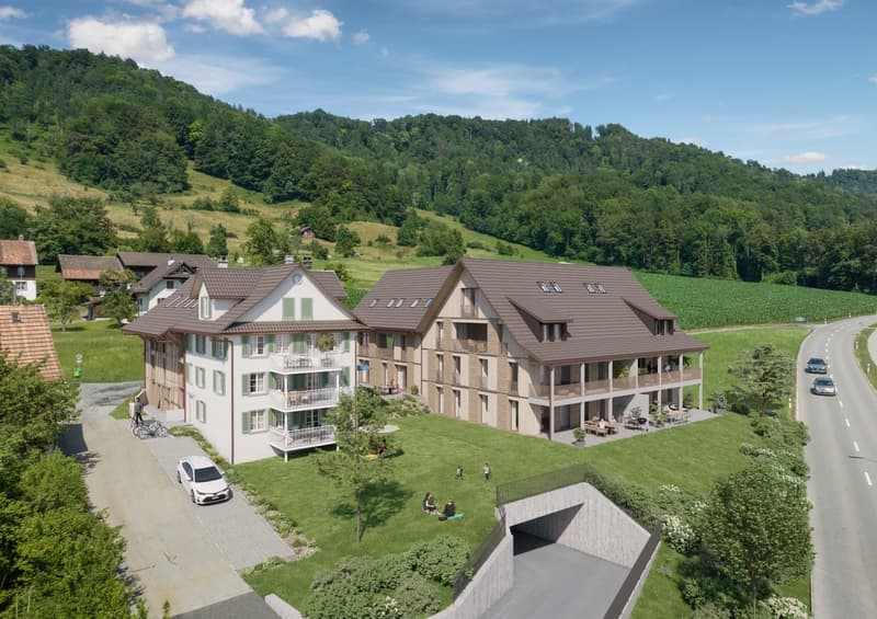 Two-story building with brown roof, white walls, balconies, and a green lawn in front.