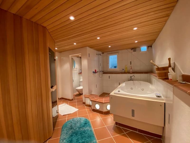 large tub, wooden wall, wooden ceiling, toilet, window, white tile